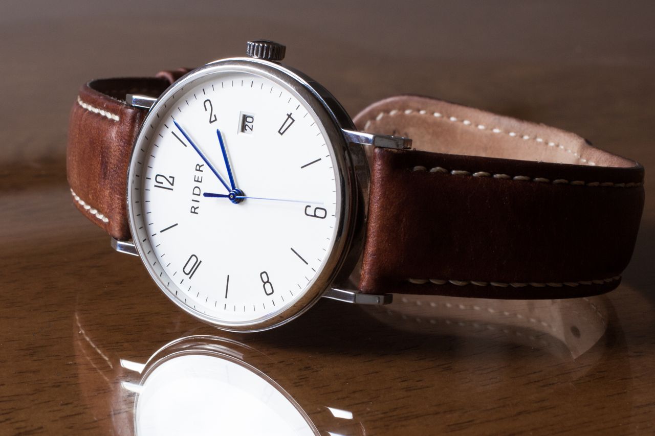 Close-up of a classic analog wristwatch with a leather strap, emphasizing elegance.